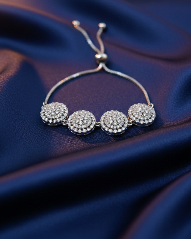 Silver bracelet with round embellishments on a blue fabric background