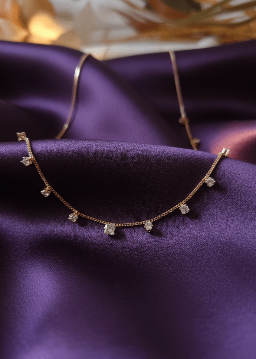 Necklace with diamond pendants on a purple fabric background