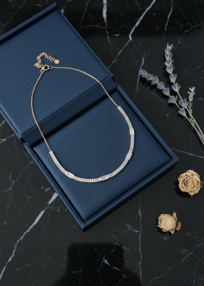 Diamond necklace on a blue jewelry box with dried flowers on a dark marble surface