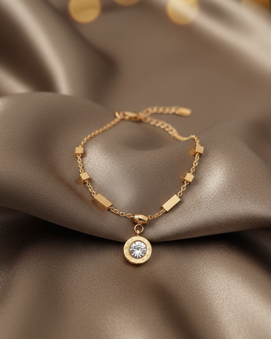 Gold bracelet with a diamond pendant on a brown fabric background