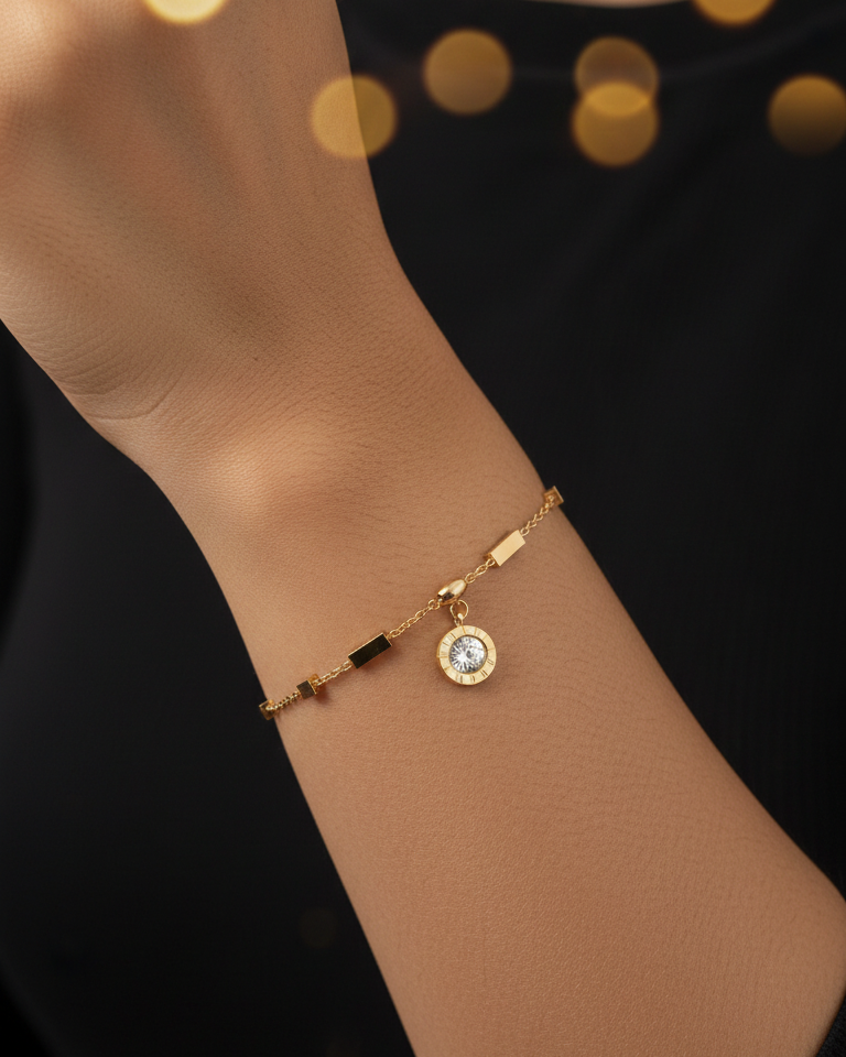 Gold bracelet with a central gemstone on a wrist against a black background