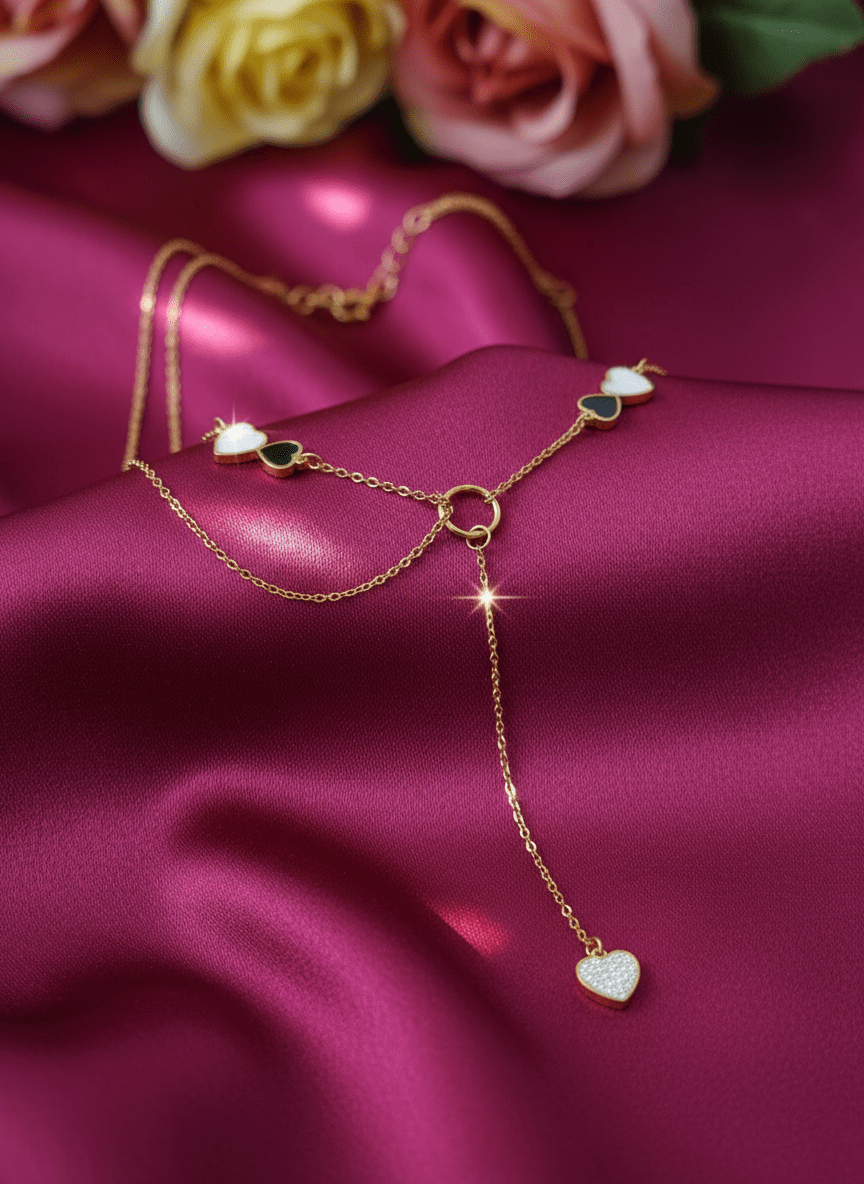 Gold necklace with heart-shaped charms on a pink fabric background
