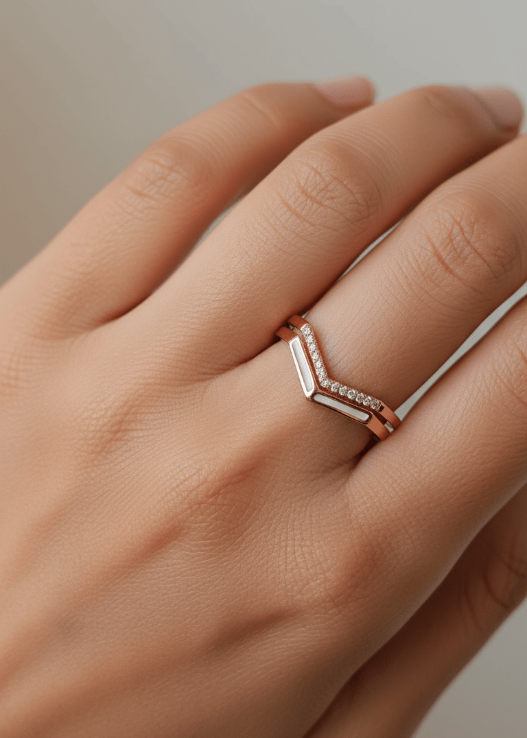 Rose gold ring with geometric design on a hand against a neutral background