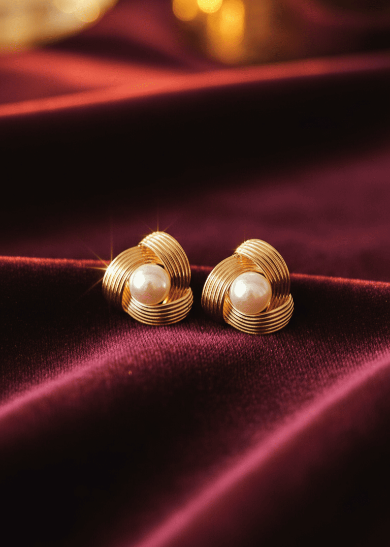 Gold earrings with pearls on a red velvet background
