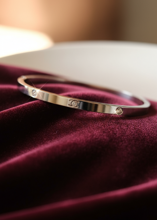 Silver bracelet with small stones on a burgundy fabric background