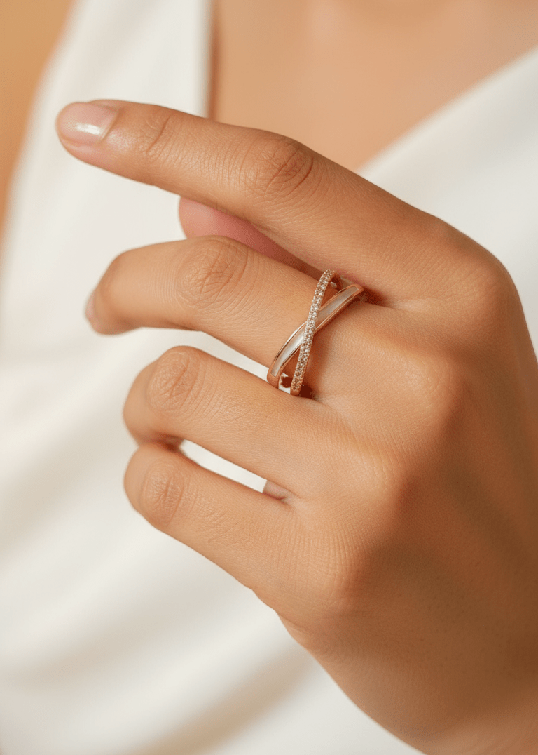 Close-up of a hand wearing a rose gold ring on a white op