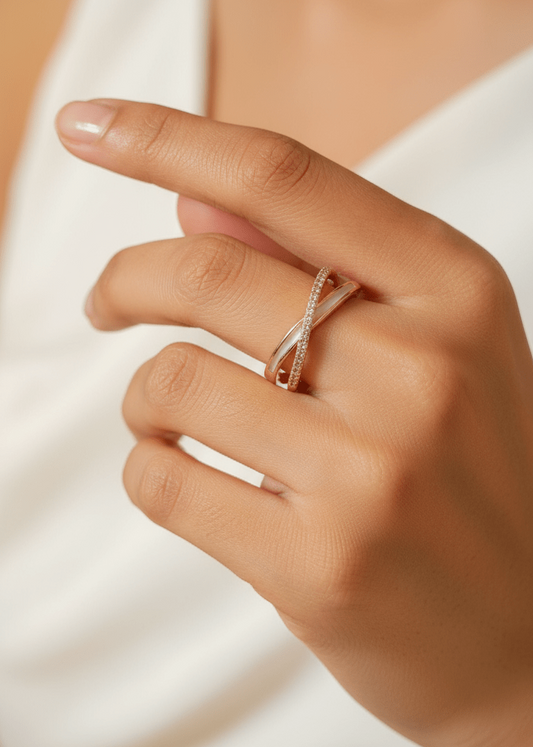 Close-up of a hand wearing a rose gold ring on a white op