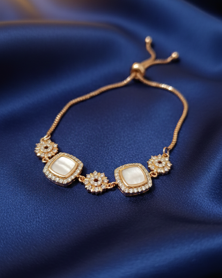 Gold bracelet with pearls on a blue fabric background