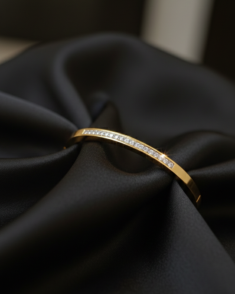 Gold bracelet with diamonds on a black fabric background